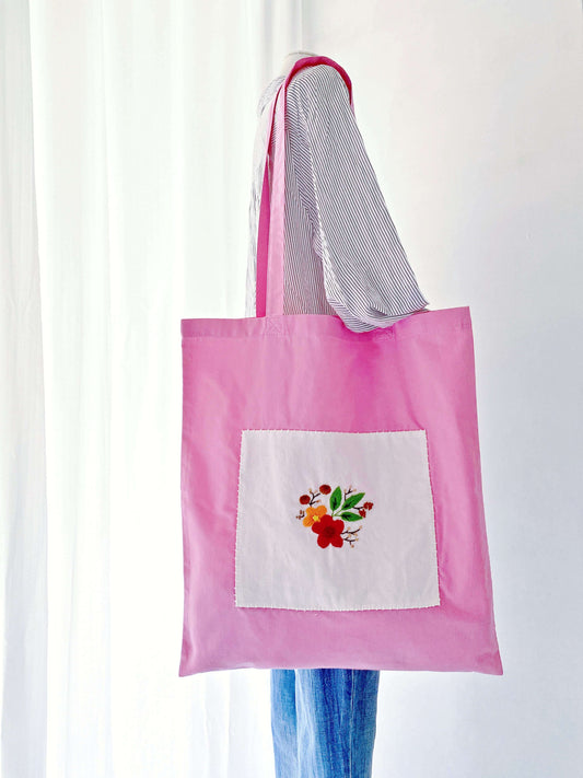 A large-capacity, lightweight cotton tote with hand-embroidered floral design, perfect for daily use or as a gift for someone who appreciates both fashion and sustainability.