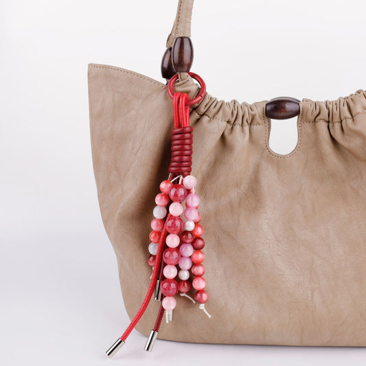 Hand-strung bead piece displayed on a shoulder bag