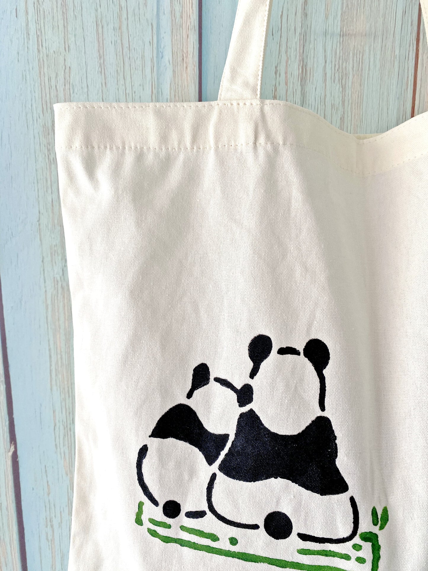 A library haul bag strong enough for heavy books, distinguished by its unique, handcrafted panda motif.