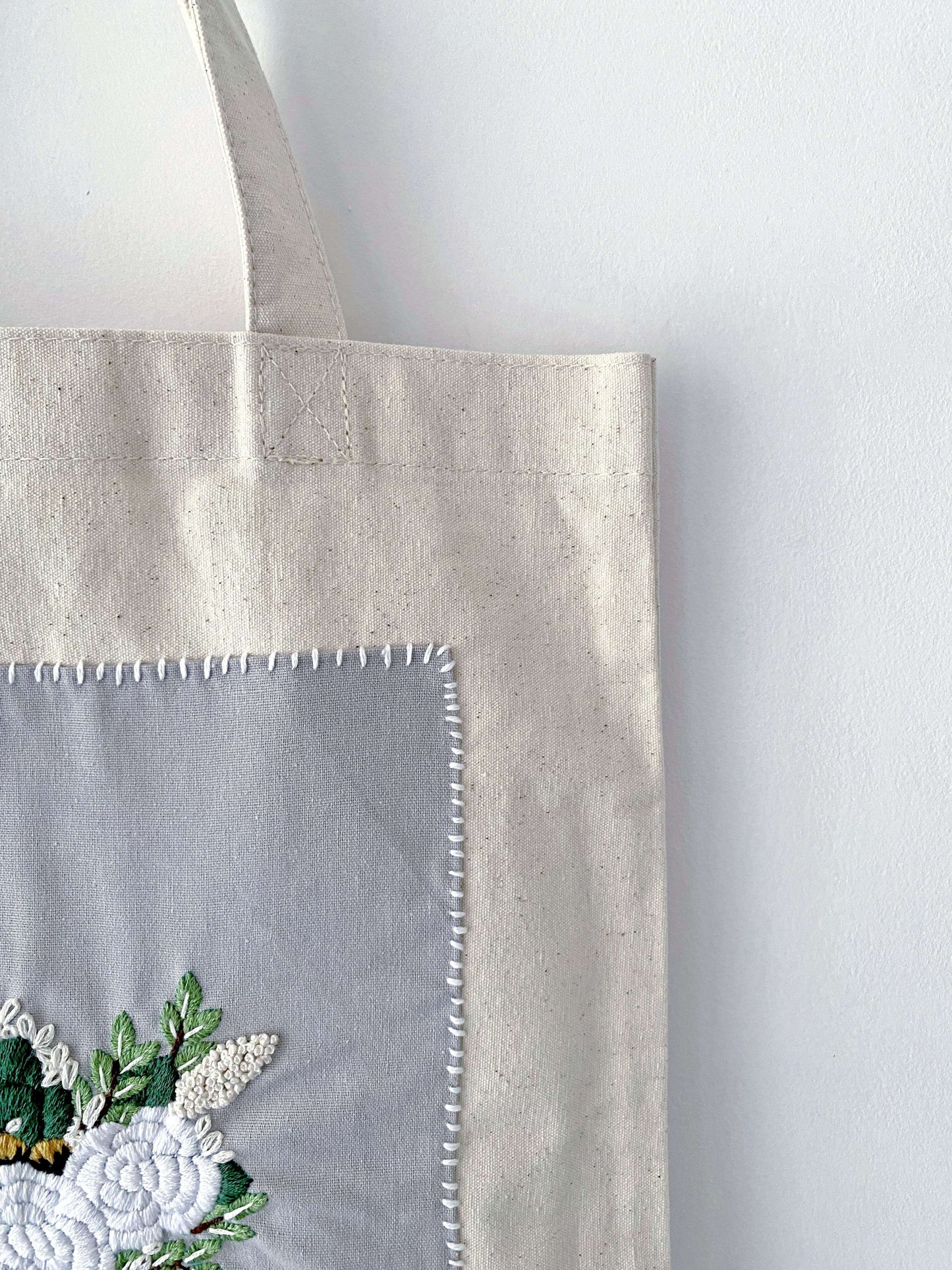 For the friend who has everything but wants nothing plastic; a natural cotton canvas gift that proves utility and high-end embroidery can coexist beautifully.
