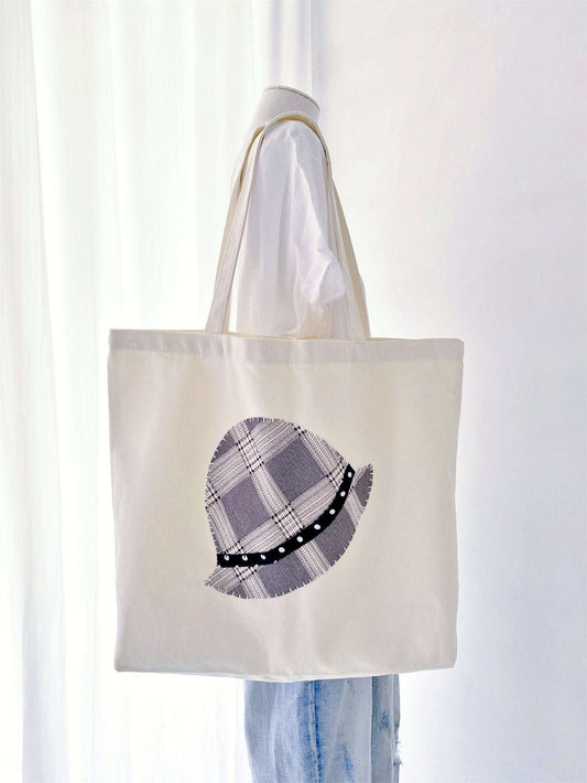 Durable oversized tote featuring handcrafted textile art. Perfectly balances modern utility with a warm, personal human touch.