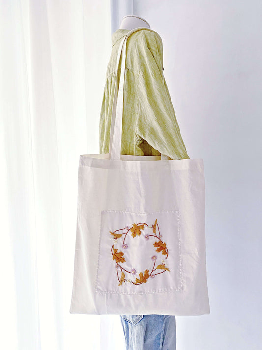 Spacious and durable cotton tote bag with floral embroidery, ideal for carrying everything sustainably.