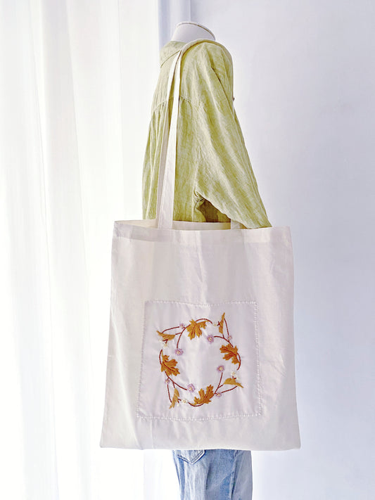 Spacious and durable cotton tote bag with floral embroidery, ideal for carrying everything sustainably.