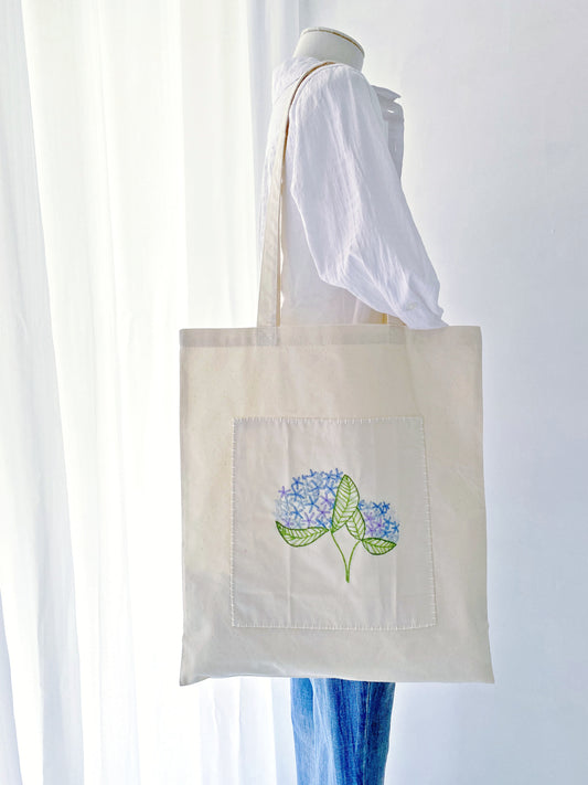 A sentimental gift for mom featuring delicate hand-stitched blooms on a super soft sustainable bag she will cherish daily.