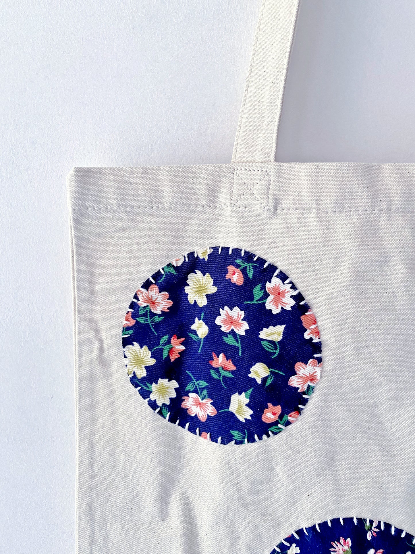 Large capacity beach tote made of breathable natural canvas showcasing intricate hand-sewn fabric art.