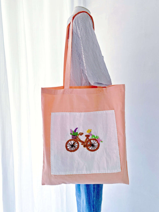 A close up of unique hand embroidered motifs on fabric that proves eco friendly fashion can be vibrant and stylish, unlike boring plain canvas shoppers.