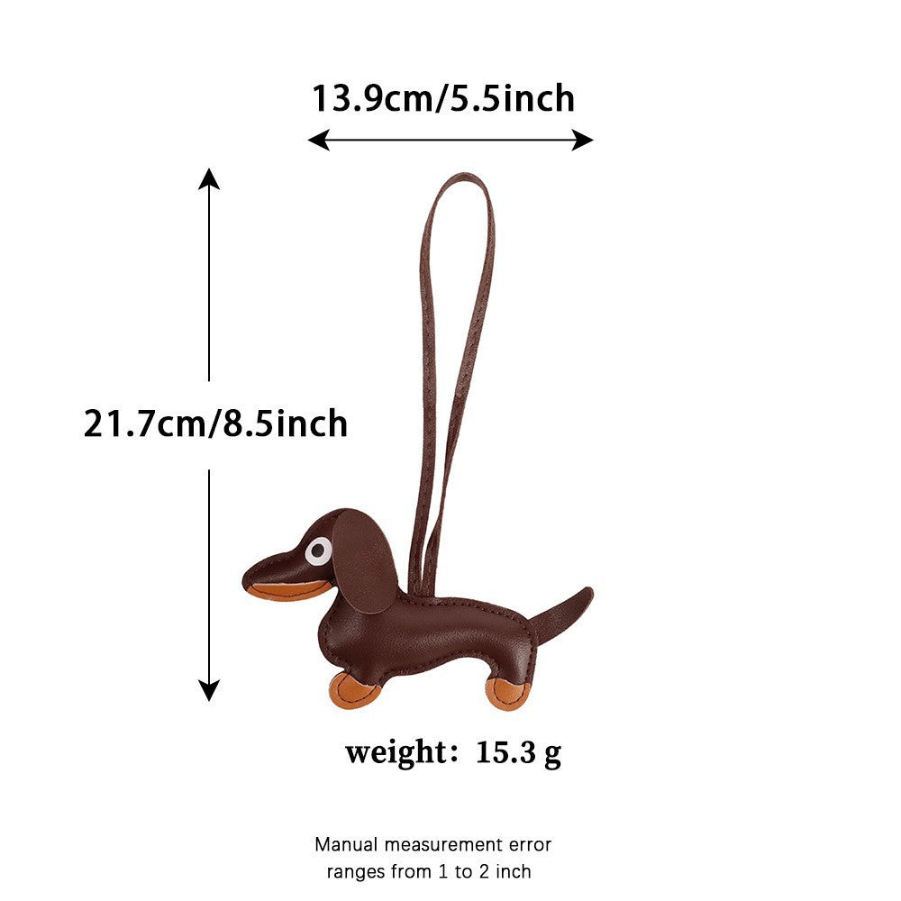 Leather sausage dog keychain accessory on a neutral crossbody bag