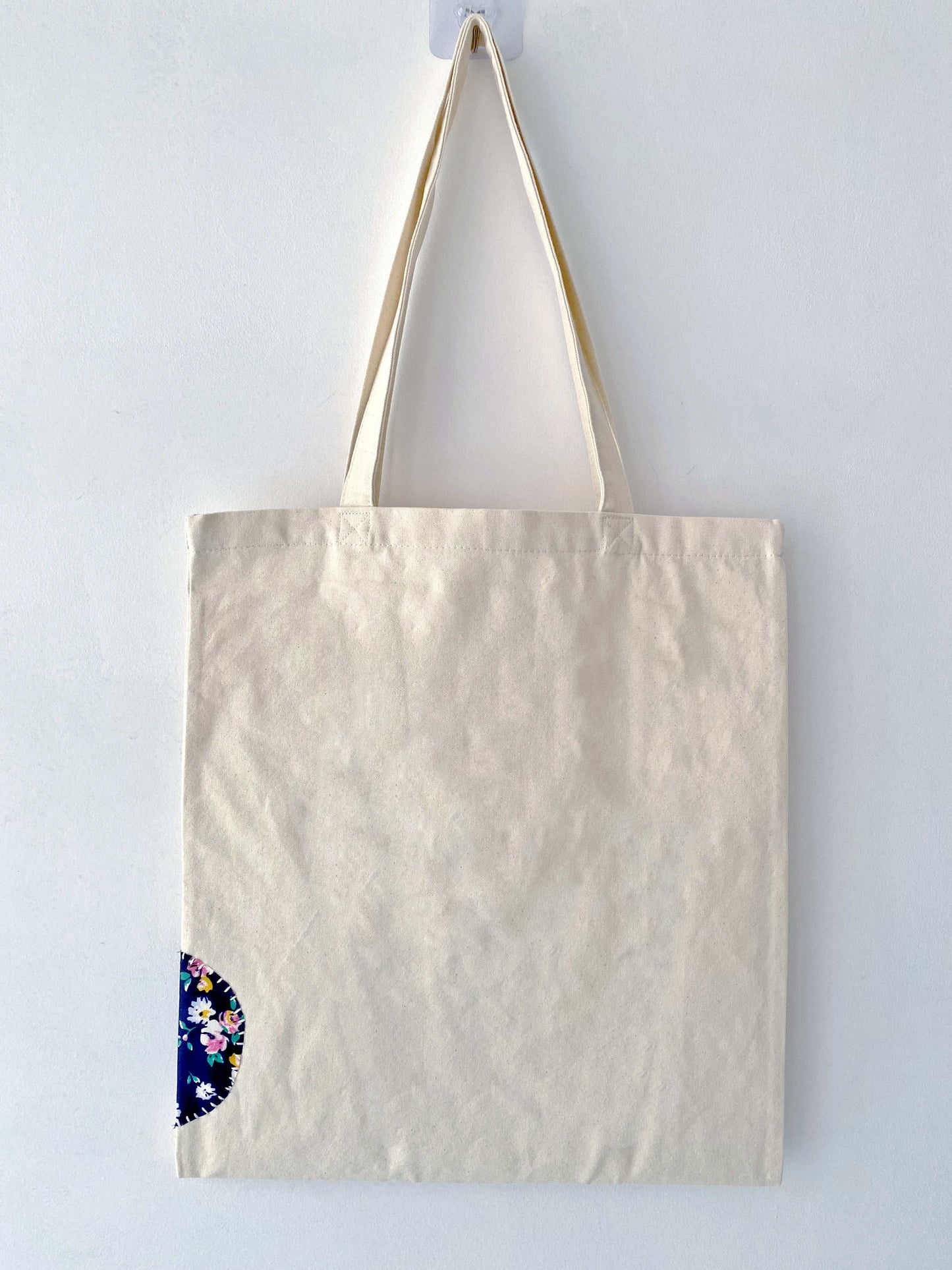 Minimalist canvas carryall updated with textured hand-stitched patchwork ideal for organizing daily work essentials.