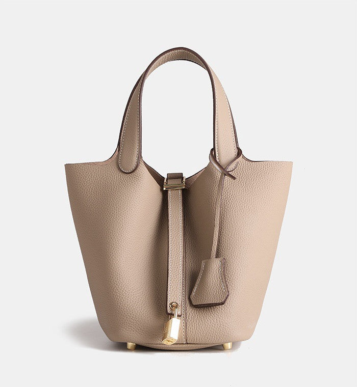 fashionable small leather bucket bag paired with neutral clothing