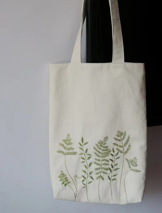 A person styled with a sustainable handmade tote bag while grabbing coffee in a cozy winter setting.