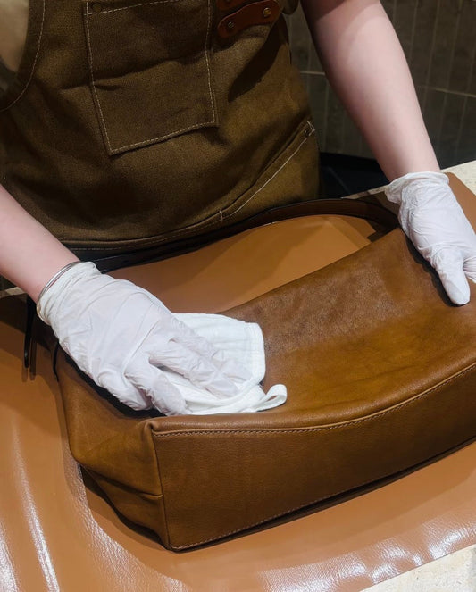 Storing a genuine leather purse in a cotton dust bag to protect it from dust and moisture