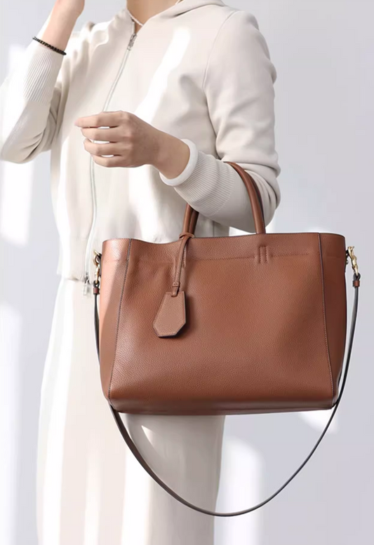 Woman carrying a dark brown leather crossbody bag with a wool coat for a winter outfit