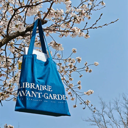 Stack of 100 eco-friendly reusable tote bags ready for event distribution.