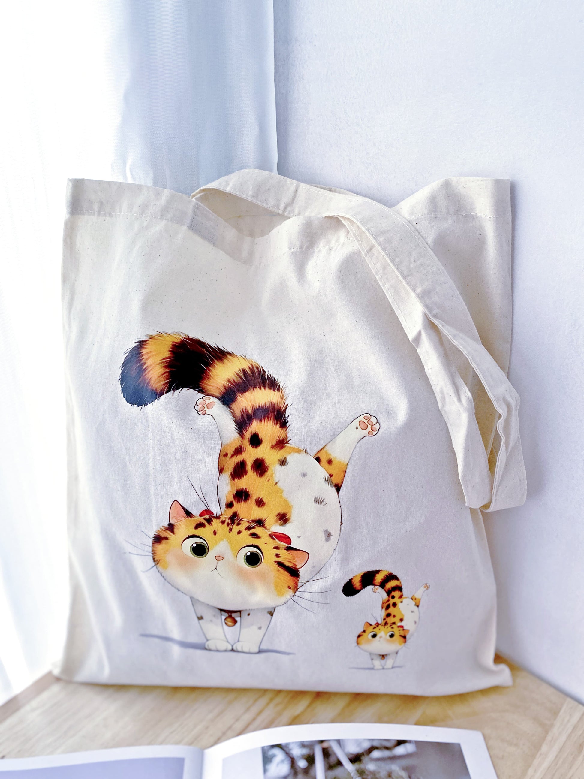 Looking for a gift that’s as practical as it is cute? This cotton tote with a hand-printed orange cat design is perfect for any occasion.