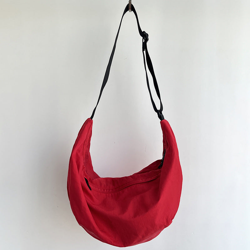 Neutral color fabric crossbody pouch with expandable main pocket