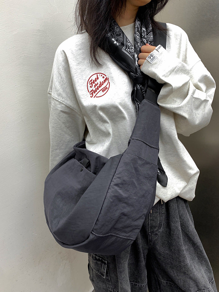 Black crescent sling bag showing interior pockets and spacious layout