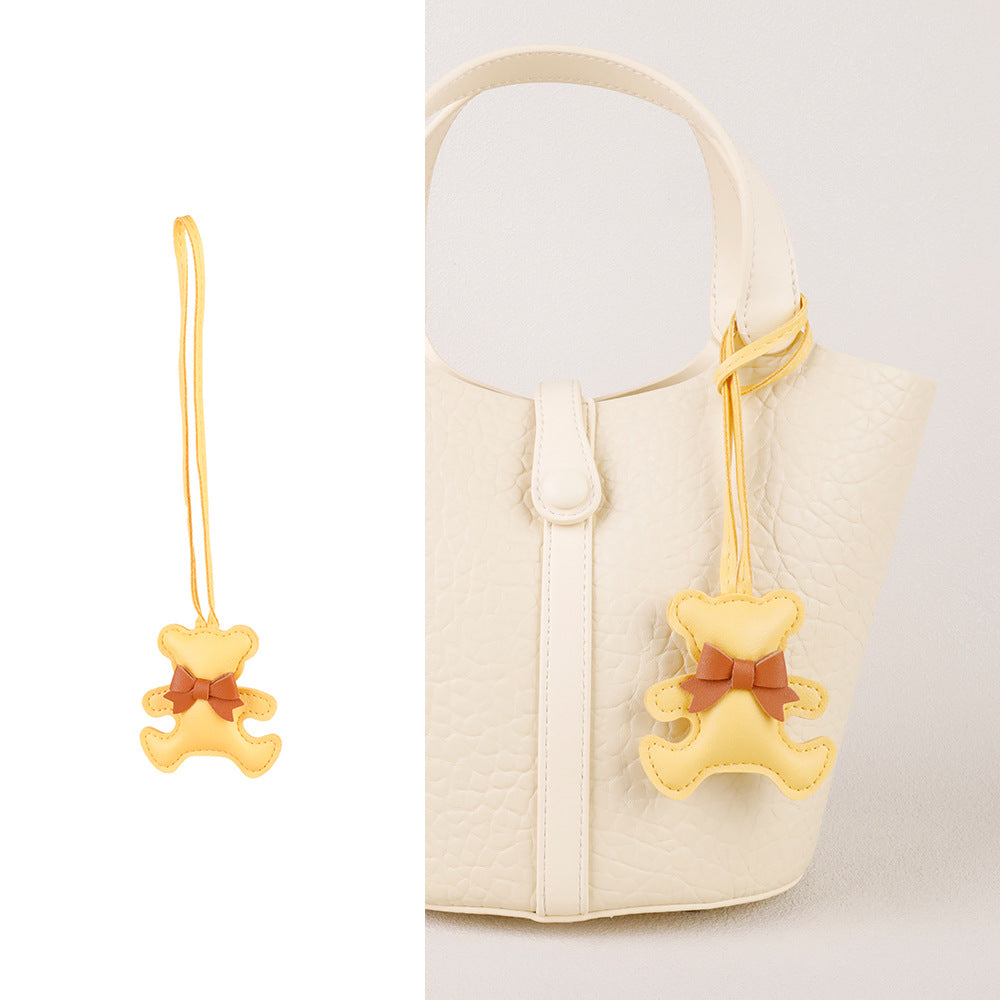 Cute bear bag charm with silk scarf swinging on a designer backpack zipper