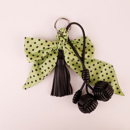 Stylish green fringe tassel charm attached to designer shoulder bag