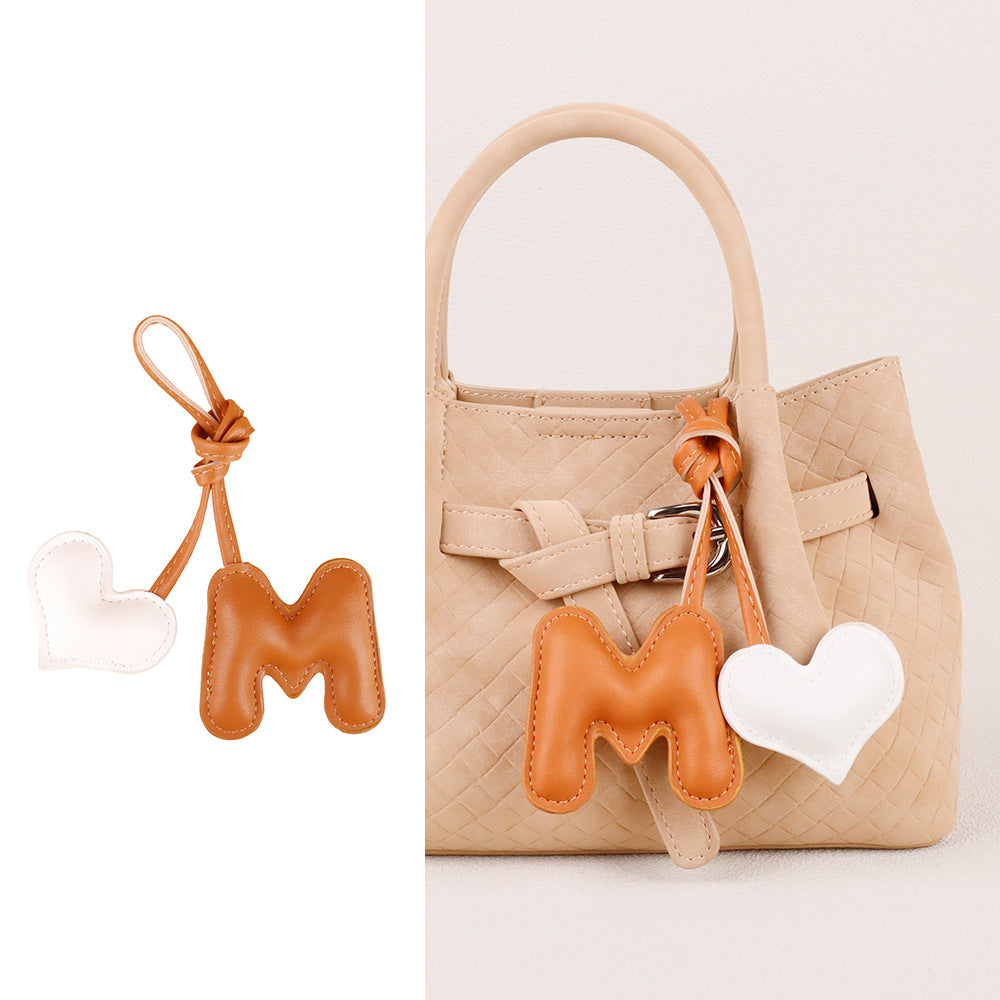 Handmade heart pendant displayed with a handbag