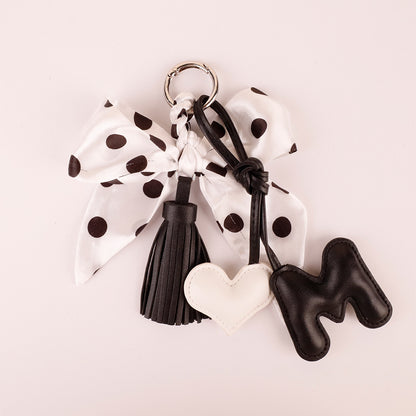 Black white bow charm with a dangling tassel