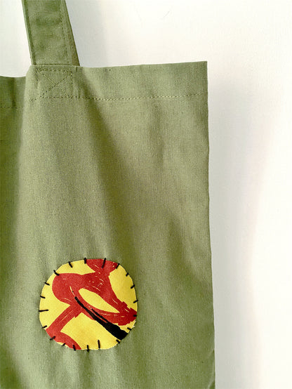 Bohemian style army green tote with unique design elements.