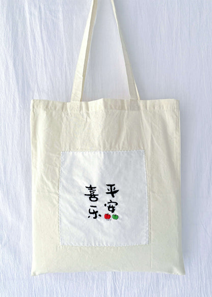 Soft organic cotton tote featuring hand-stitched Chinese calligraphy, a sustainable choice for plastic-free market days.