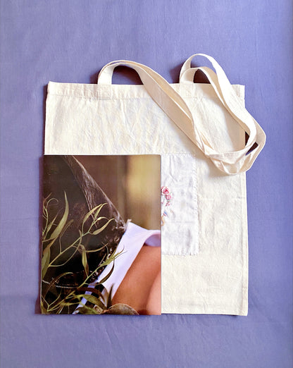 Texture detail of raised hand-embroidered roses on smooth, breathable natural fabric.