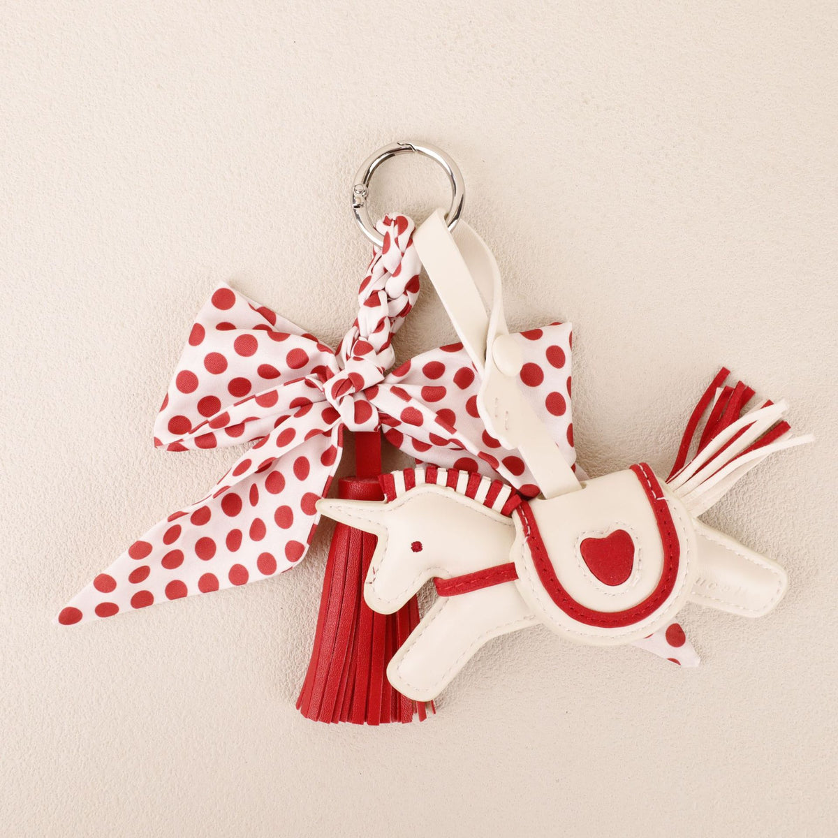 Red bow and tassel pendant attached to a shoulder bag