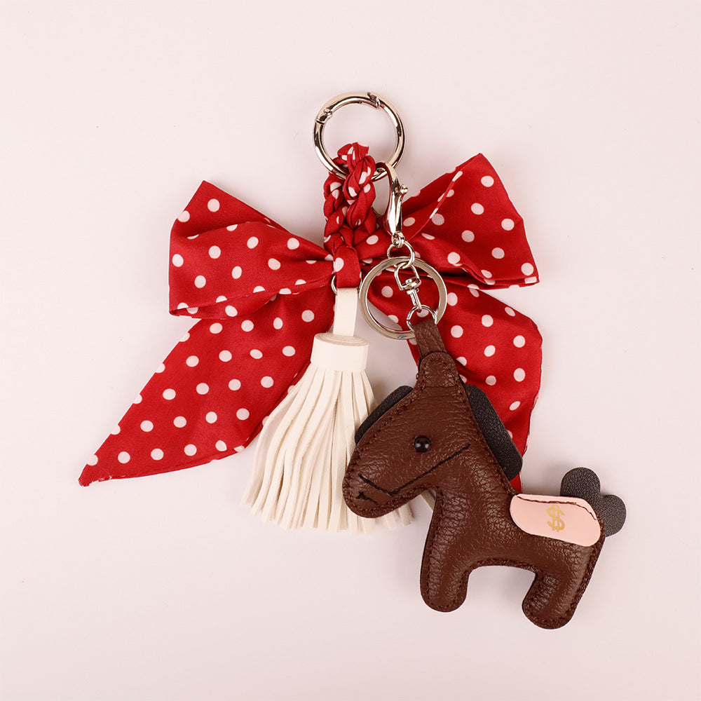 Women's bag accessory featuring a red spotted bow and tassels