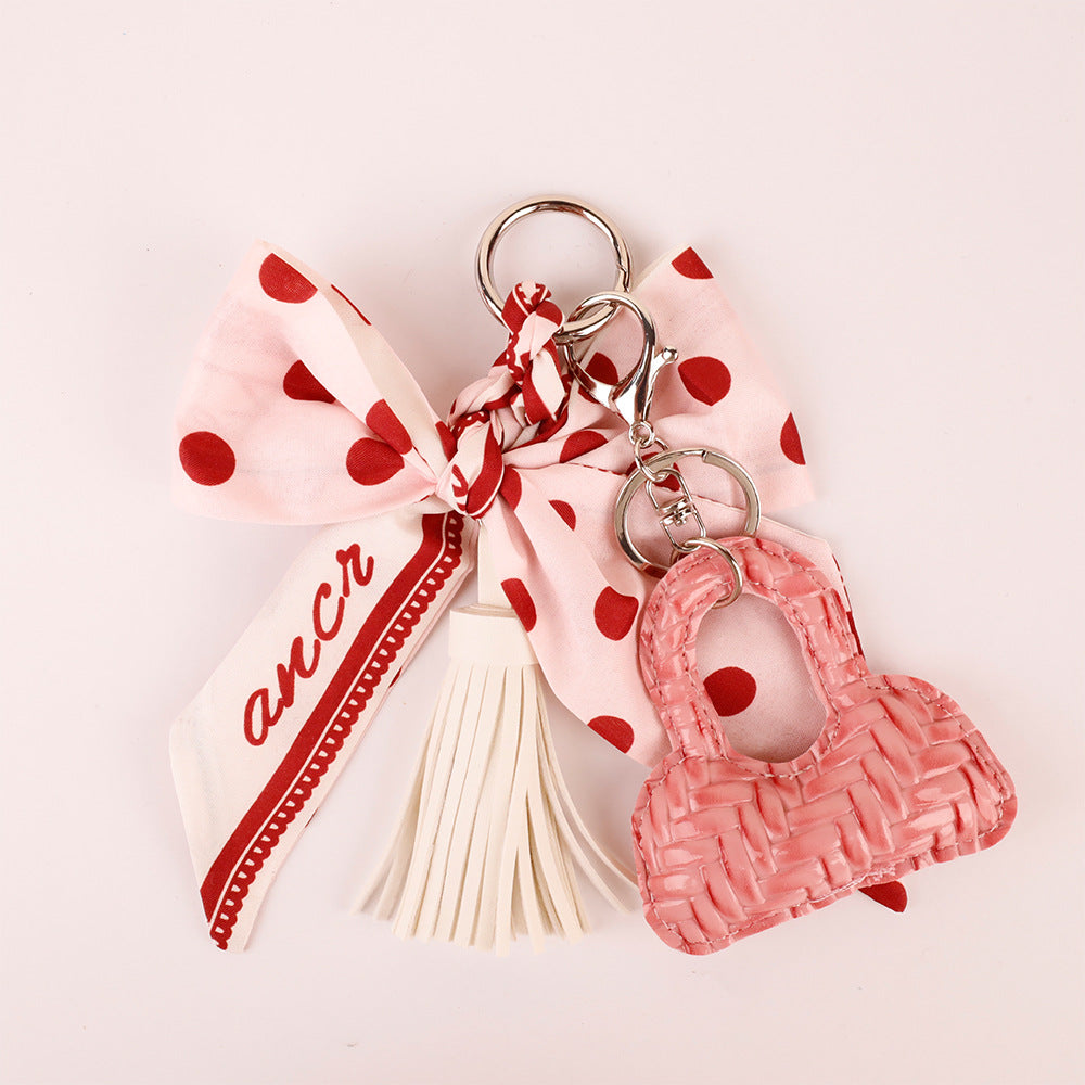 Scarf-style pink bow charm with dangling PU leather tassels