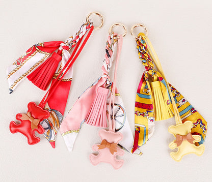 Close-up view of a bear purse charm with intricate silk scarf stitching