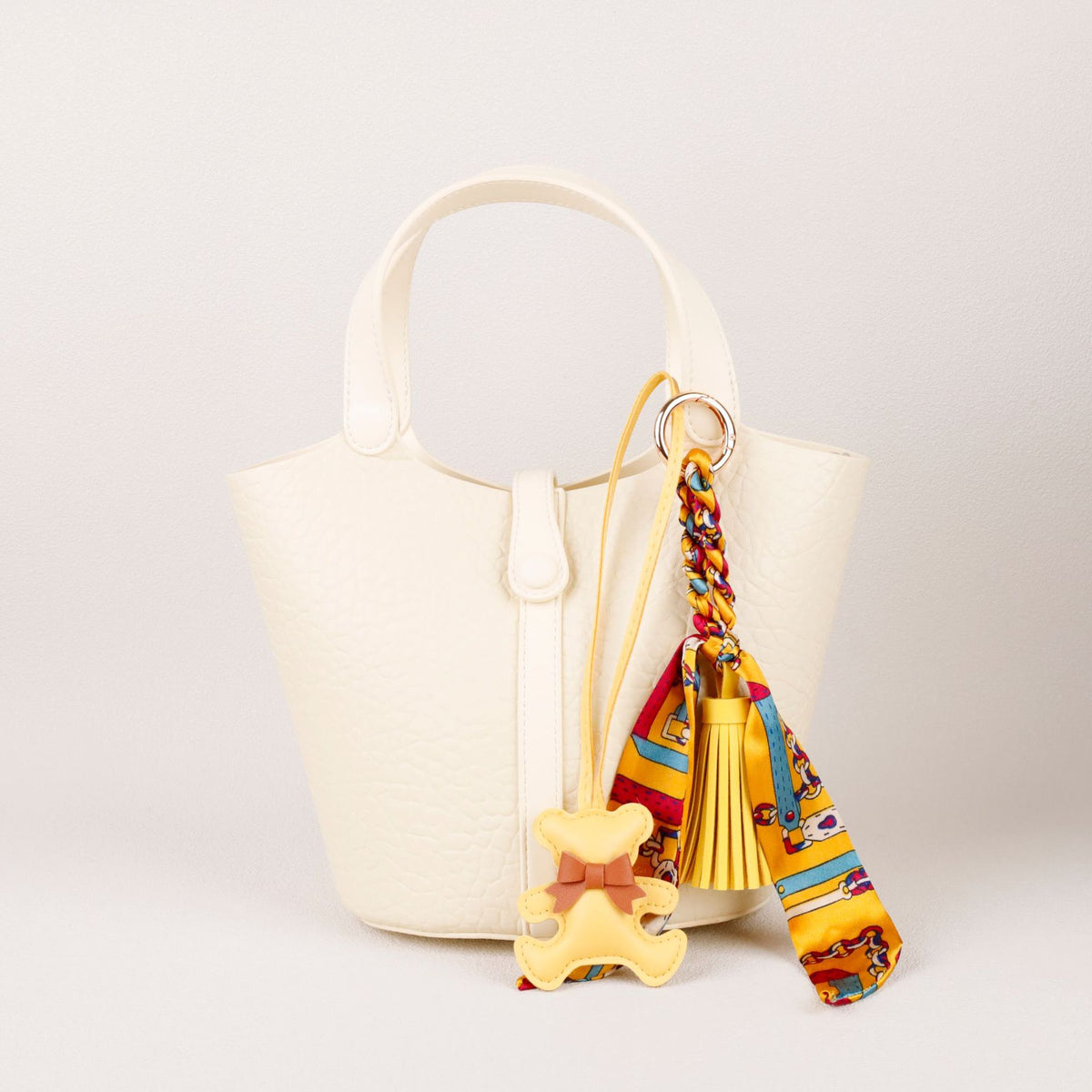 Chic designer bag accessory featuring a faux leather bear and tassel accent