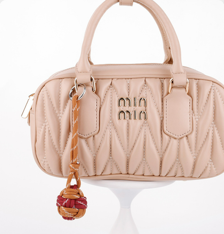 Small woven cord accessory with colorful ball details
