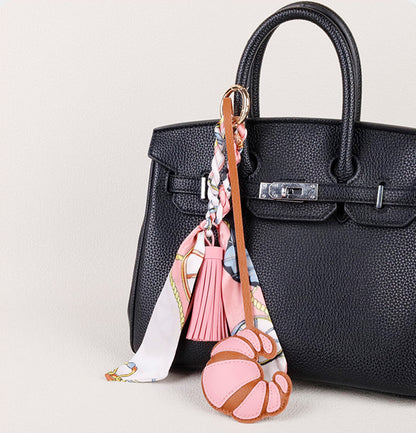 Handmade scarf detail paired with a flowing tassel on a purse