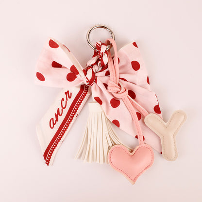 Pink tassel keychain with a scarf-inspired bow