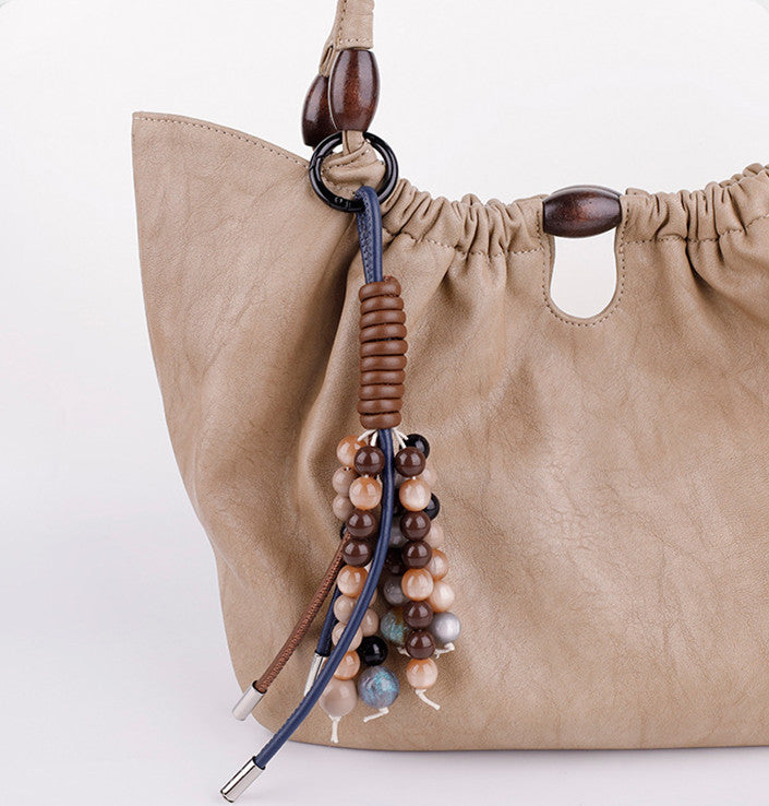 Handcrafted crystal and bead phone charm attached to a modern smartphone case