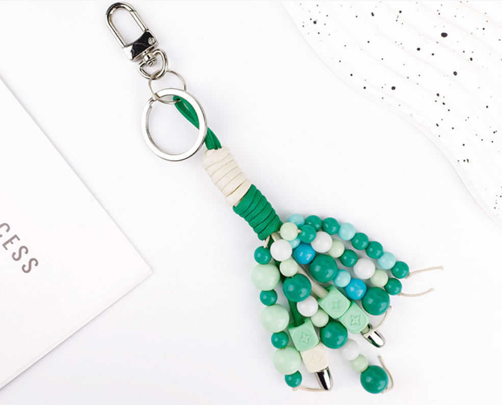 Handmade braided charm styled on a neutral tote