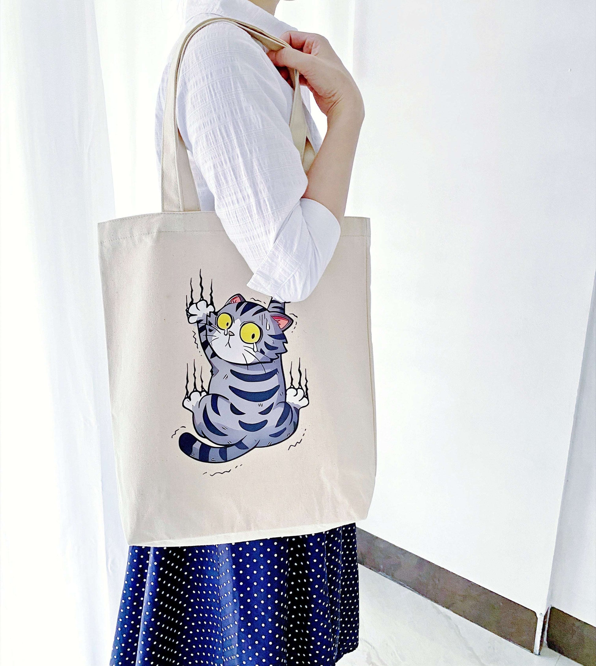 Hand-printed canvas tote bag packed with library books and a laptop for a study session