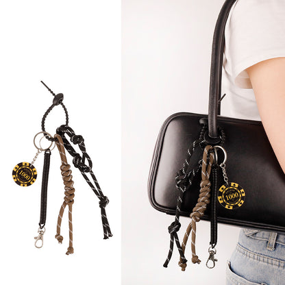 Tassel keychain accessory clipped to a tote bag