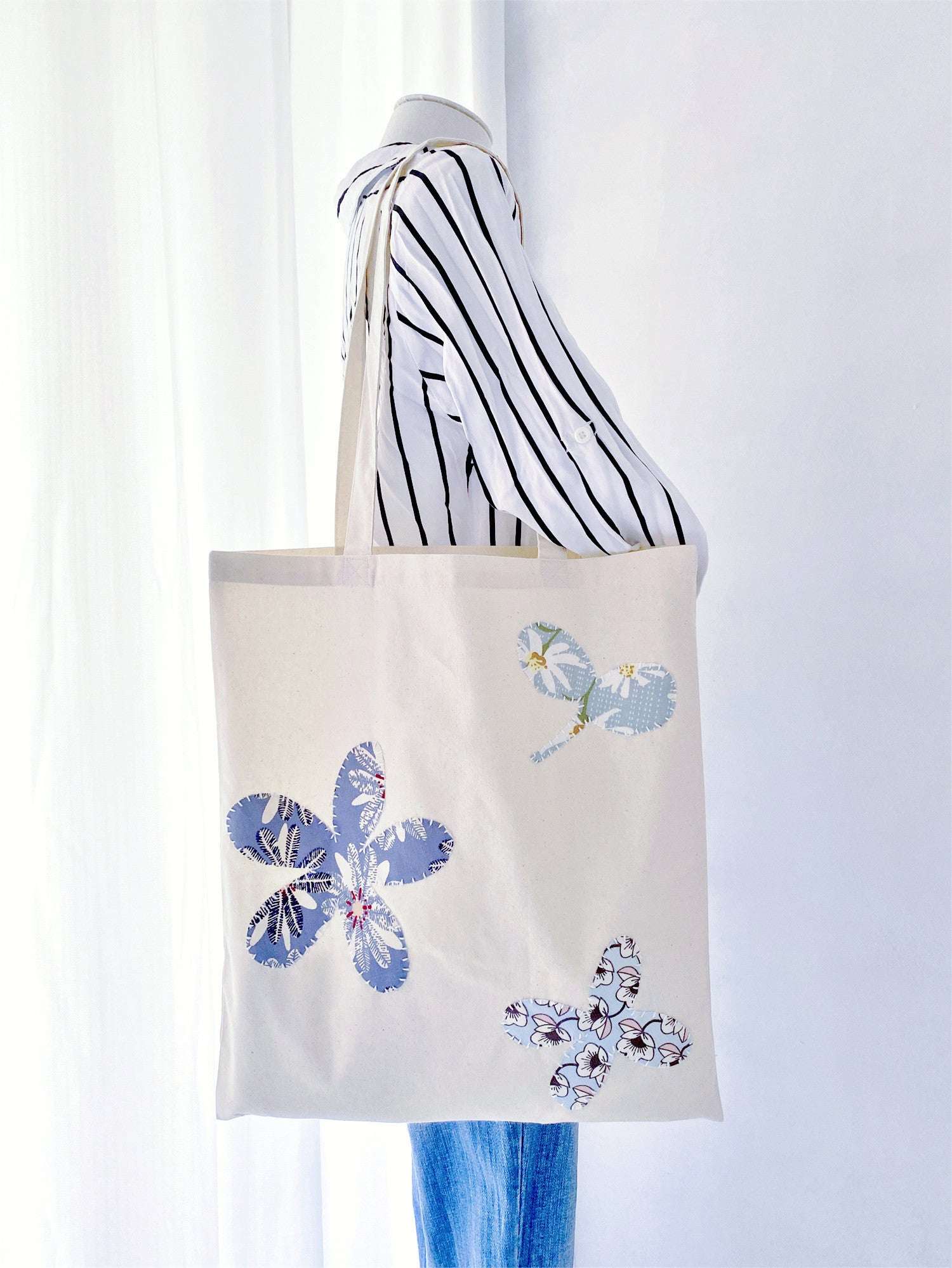 Sustainable cotton tote with subtle hand-stitched patchwork, appreciated by people who enjoy carrying objects that feel personal rather than mass-produced