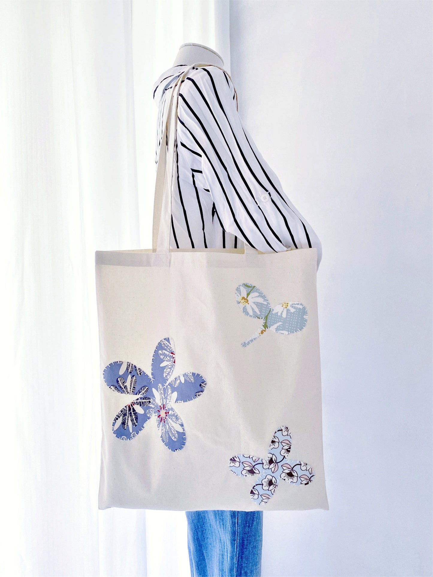 Sustainable cotton tote with subtle hand-stitched patchwork, appreciated by people who enjoy carrying objects that feel personal rather than mass-produced