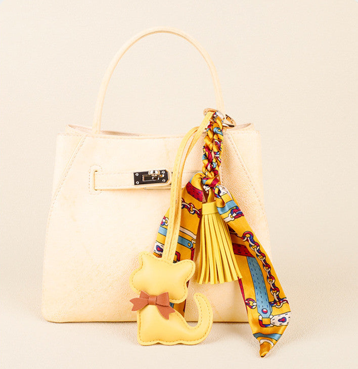 Small cat charm hanging from a handbag