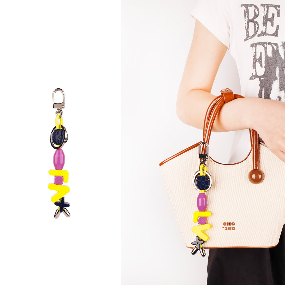Colorful bag chain attached to neutral crossbody purse