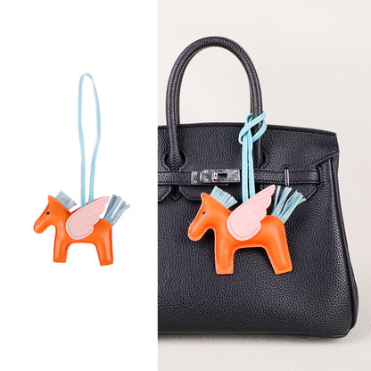 Saddle brown horse purse pendant dangling from a sleek laptop tote bag handle