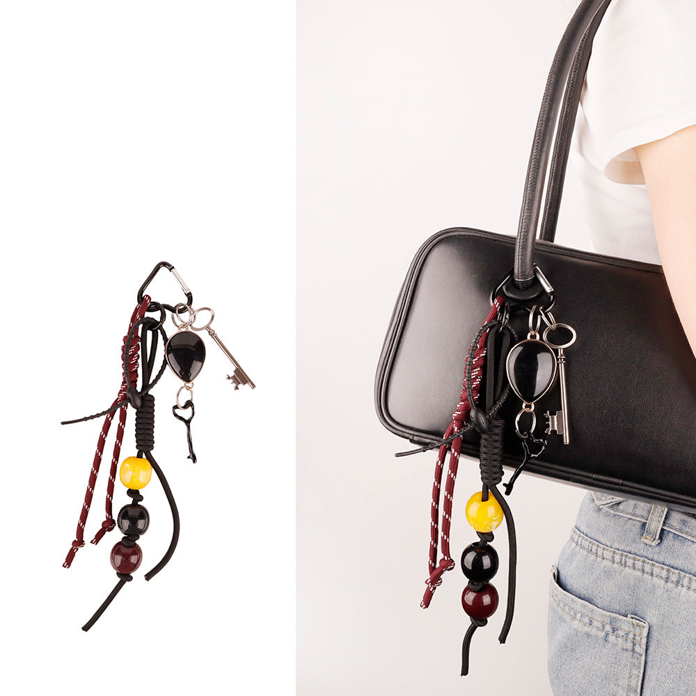 Custom woven tassel clip attached to a work laptop bag