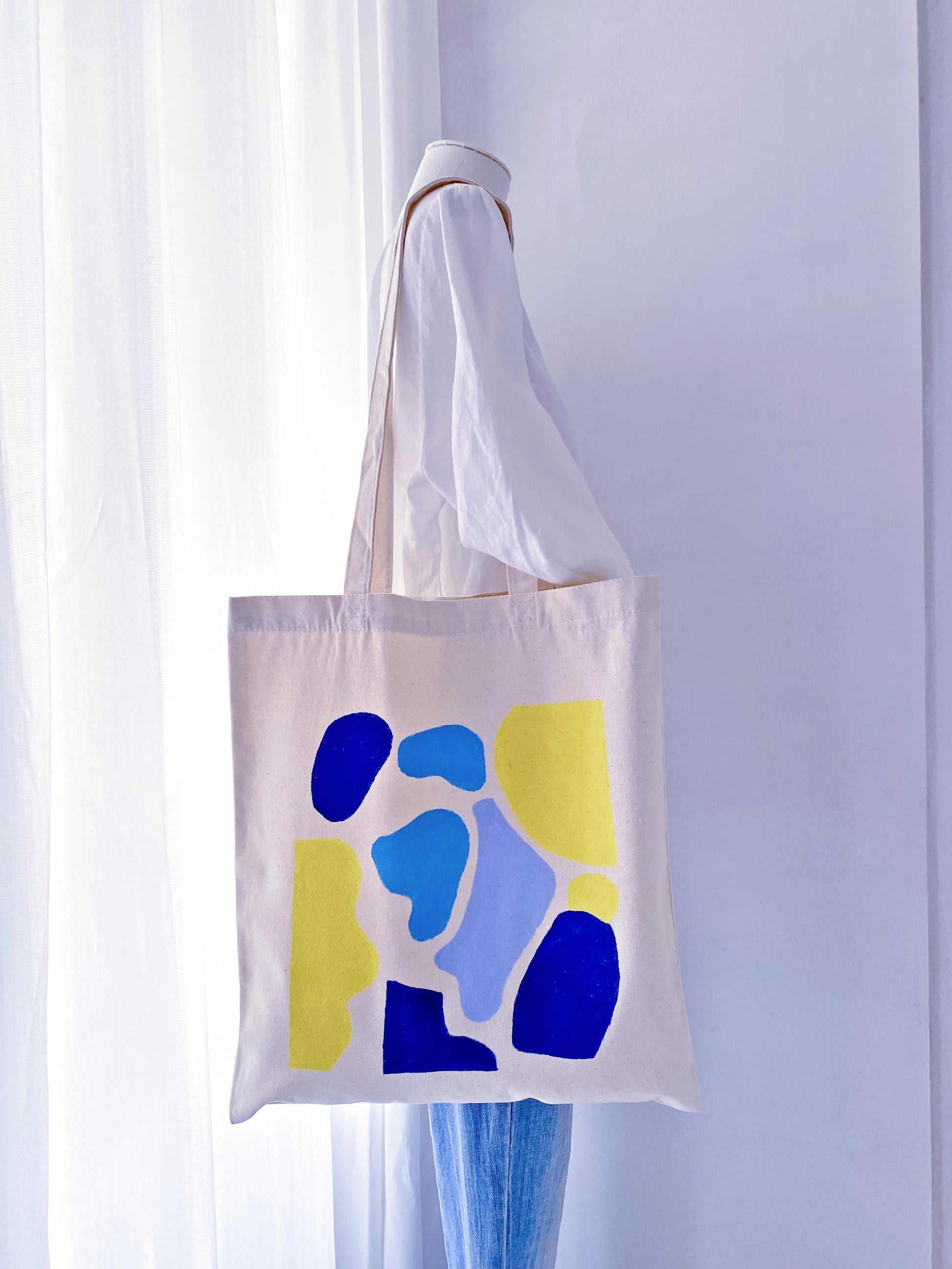 Minimal canvas bag resting beside a notebook and laptop in a calm workspace setup