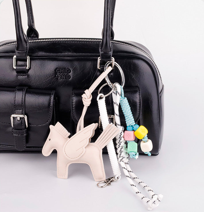 Colorful horse bag decoration styled with a woven cord loop