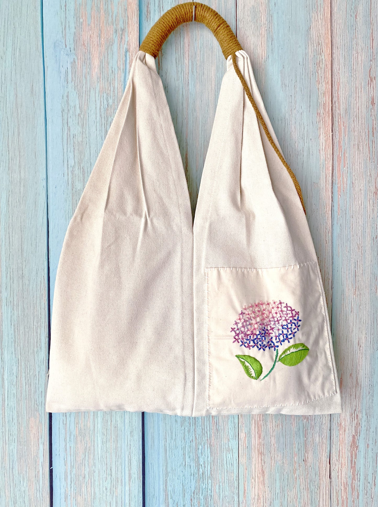Handmade floral embroidery on eco-friendly canvas tote for sustainable living.