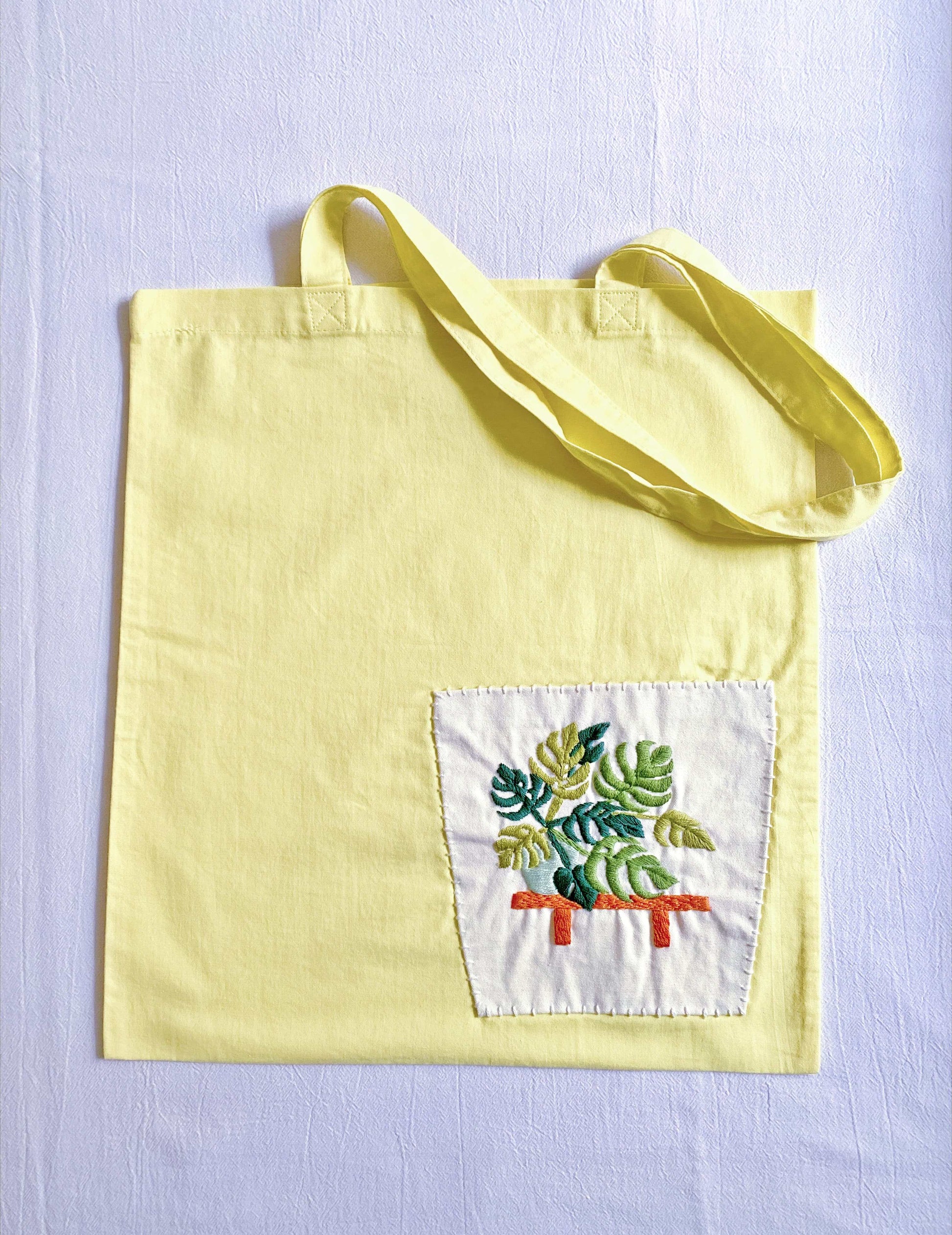 Soft lightweight yellow canvas tote with botanical embroidery, suitable as a birthday or holiday gift