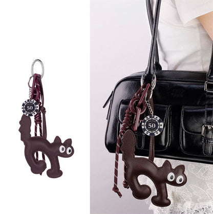 Orange tabby cat keychain clipped to a dark daily purse handle